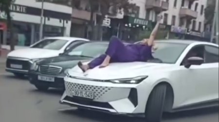 Bakıda qəribə hadisə: Qadın küçədə avtomobilin üzərinə uzandı, hərəkət iflic oldu - VİDEO